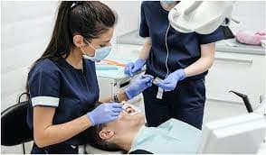 Dental hygienist assistant working with dentist