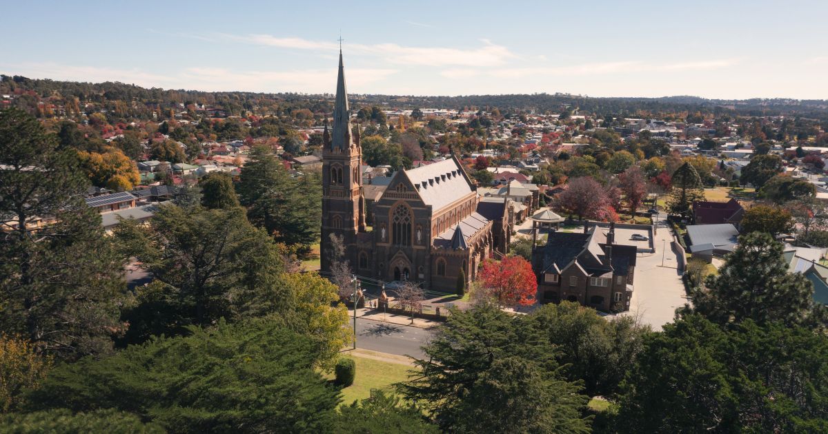 Academic Jobs Panoramic view of Armidale city with lush greenery and historic architecture